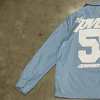 Back print of the PVTLTD* Rush Hour Blue Shirt photographed on concrete