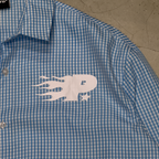 Close-up of the white flame logo on the PVTLTD* Rush Hour Blue Shirt