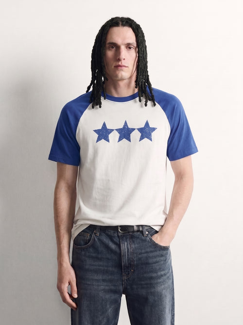 PVTLTD* Blue Raglan Tee, close-up of the speckled three-star chest print on the off-white body