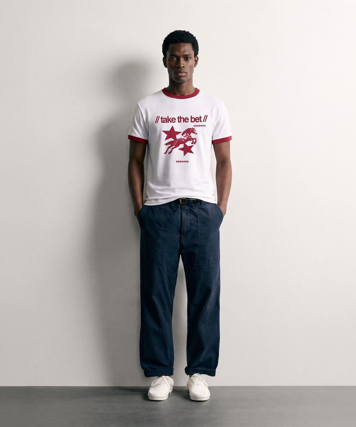 Model wearing the PVTLTD* Horsebet Slim Fit Tee, white ringer tee with red trim and take the bet horse print, front view