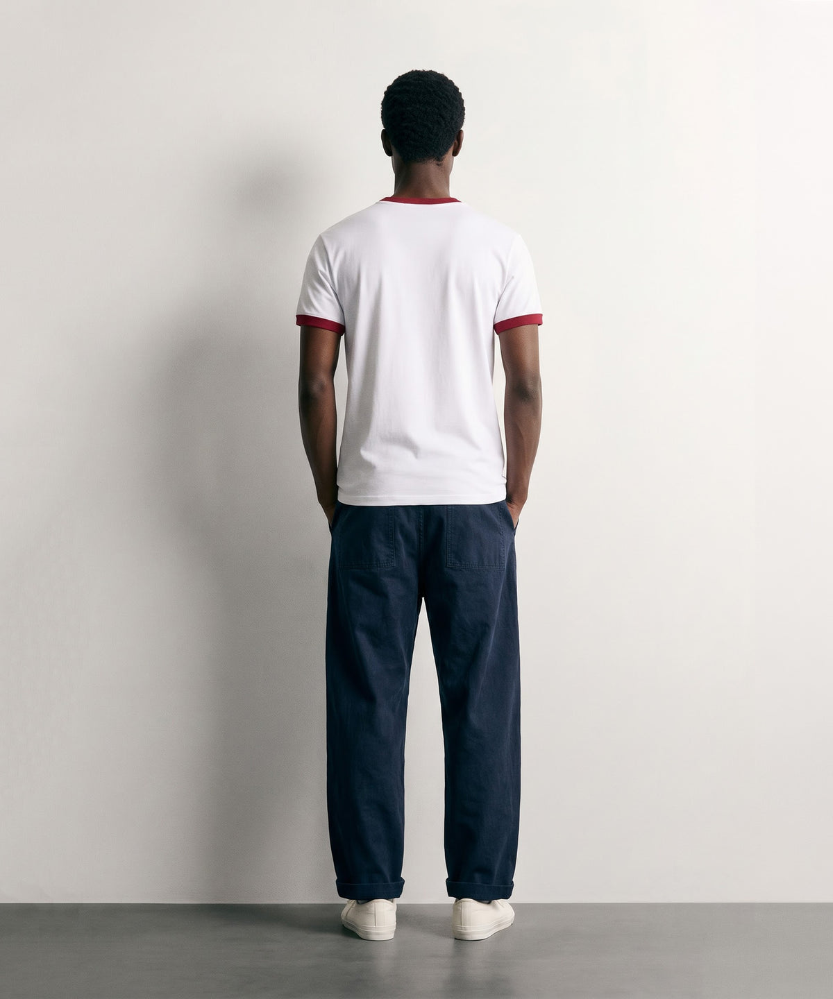 Back view of the PVTLTD* Horsebet Slim Fit Tee on model, plain white body with red collar and sleeve trim